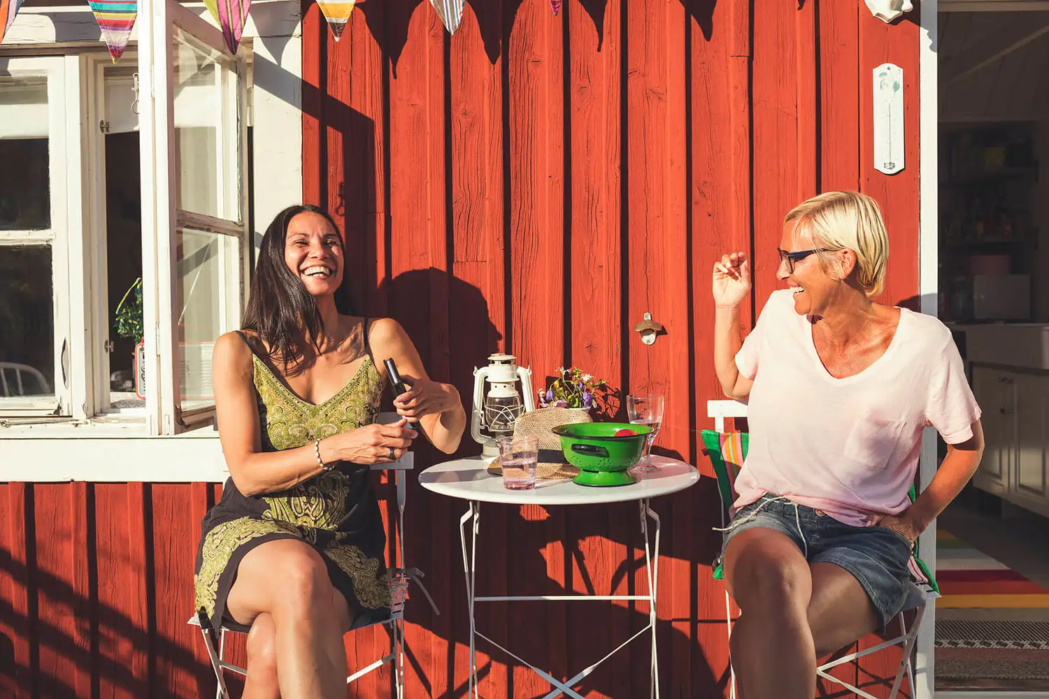 Two happy women chatting outside a cafe